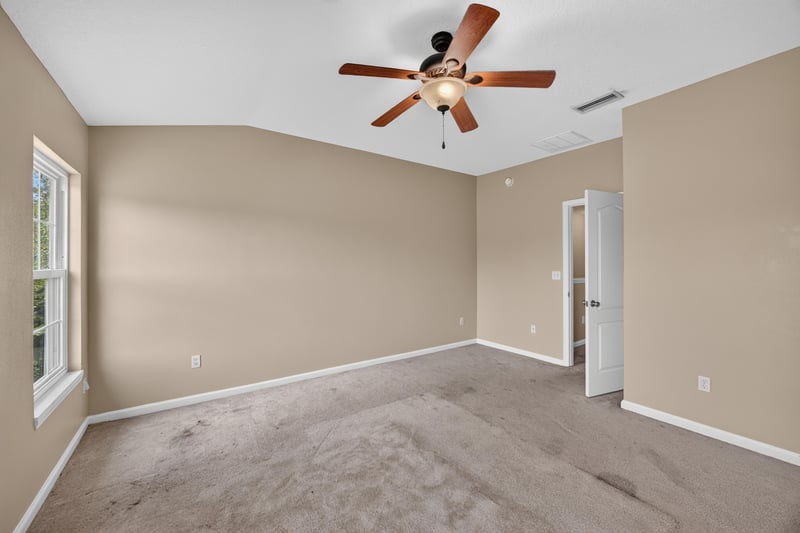 Bedroom with carpet, ceiling fan and large windows at 1572 Biscayne Bay Dr, Jacksonville, FL 32218