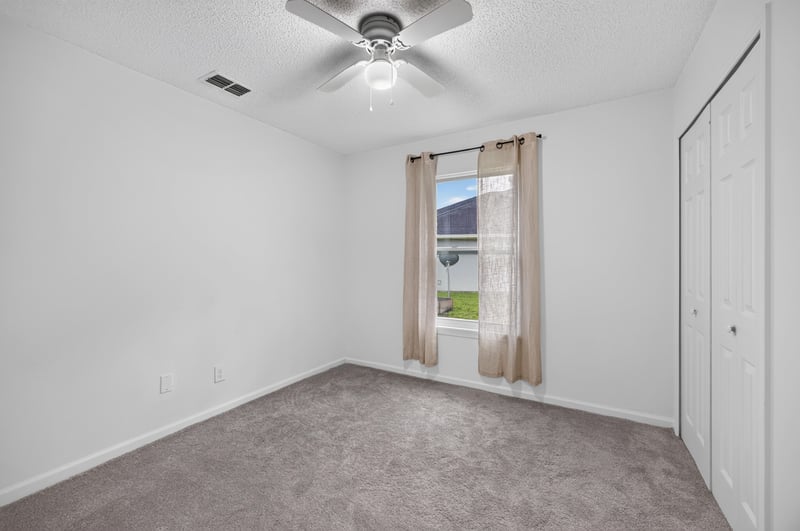 Bedroom with bed and nightstands at 8921 Needlepoint Pl, Jacksonville, FL 32244