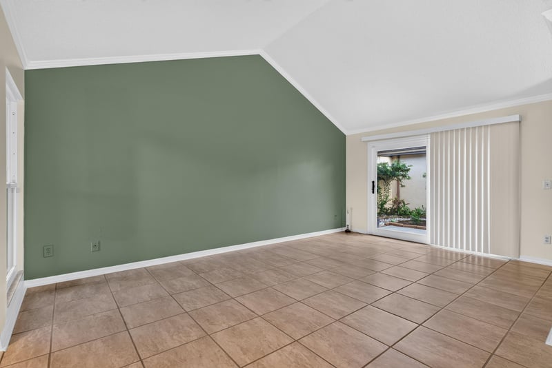 Living room with green accent wall and sliding door at 3515 Cormorant Branch Ct, Jacksonville, FL