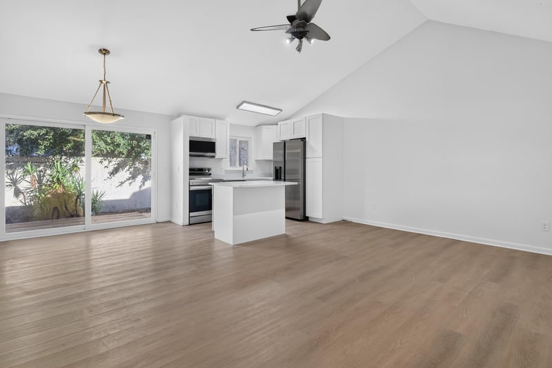 Open living and kitchen area with sliding glass door at 8177 Virgo St, Jacksonville, FL 32216