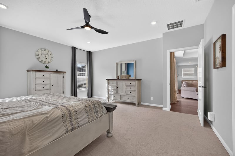 Primary bedroom with dresser and doorway to bath at 2354 Jennings Farm Dr, Middleburg, FL 32068