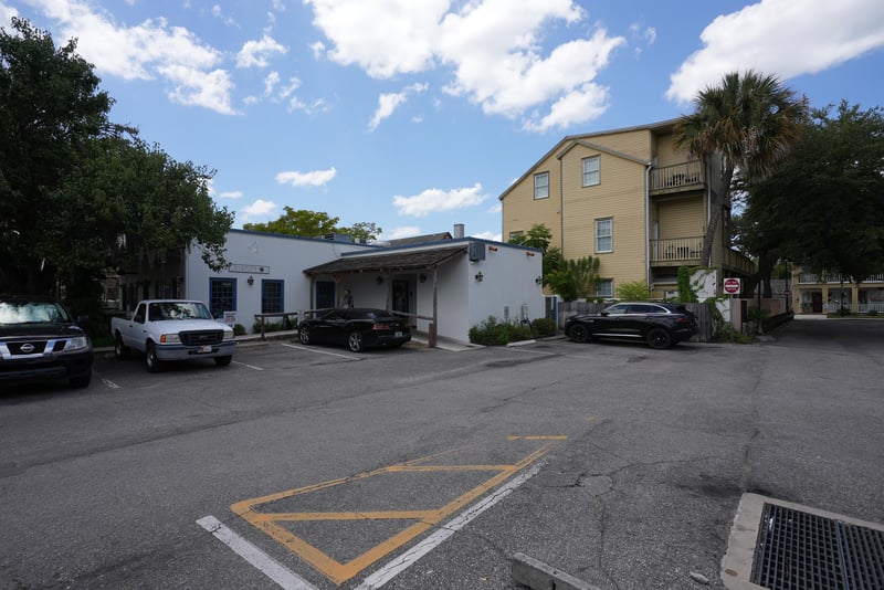 Yellow three-story building with on-site parking and shade trees at 29 Cuna St, St. Augustine, FL 32084