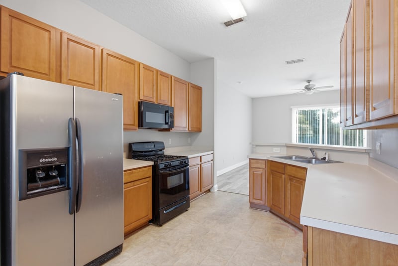 Kitchen view with stainless refrigerator and wood cabinets at 14187 Big Spring St, Jacksonville, FL 32258