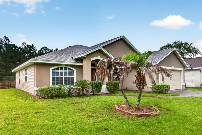Front exterior with palm tree and arched window at 706 Bonaparte Dr, Jacksonville, FL 32218