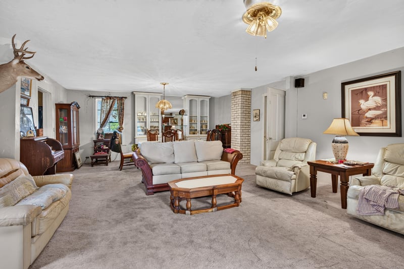Living room with brick accent and upholstered chairs at 1173 US-17, Satsuma, FL 32189