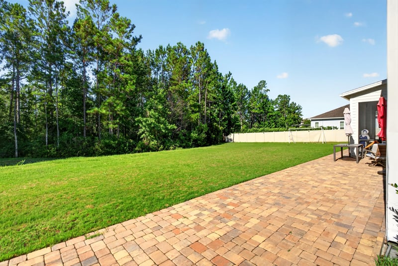 Backyard view toward tree line at 22 Azura Point
