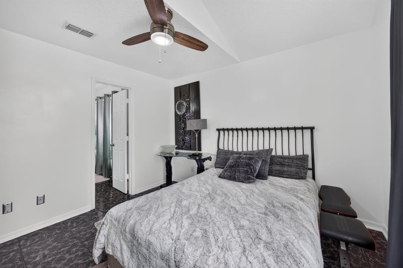 Bedroom with ceiling fan and dark bedding at 1346 Gately Ct, Jacksonville, FL 32225