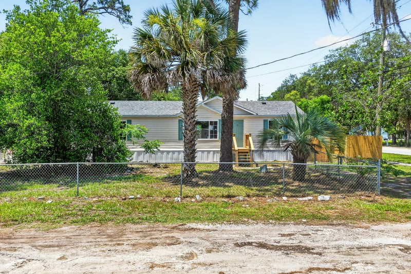 Front exterior with unfinished dirt yard at 7603 Coach Park Dr, Jacksonville, FL 32244