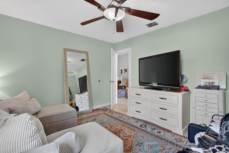 Bedroom with mirror and wall-mounted TV at 13020 Medford Ln, Jacksonville, FL 32225