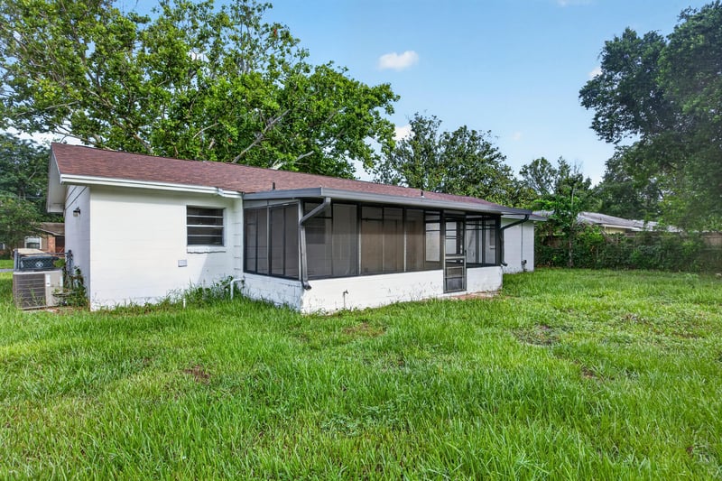 Rear exterior with screened porch and lawn at 12351 Condor Dr