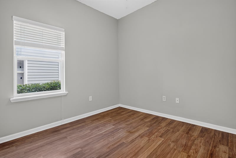 Bedroom with window and wood-look flooring at 8196 Cabin Lake Cir, Jacksonville, FL 32256