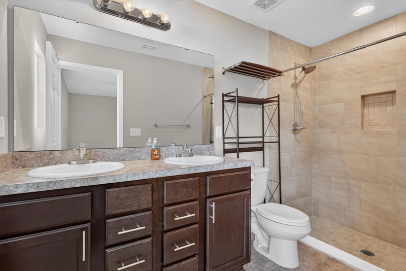 Bathroom vanity with granite-look counter and shower at 7253 Townsend Village Ct, Jacksonville, FL
