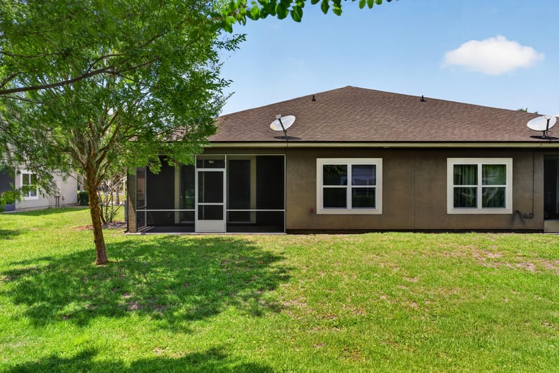 Backyard lawn with trees and rear elevation at 2378 Caney Oaks Dr, Jacksonville, FL