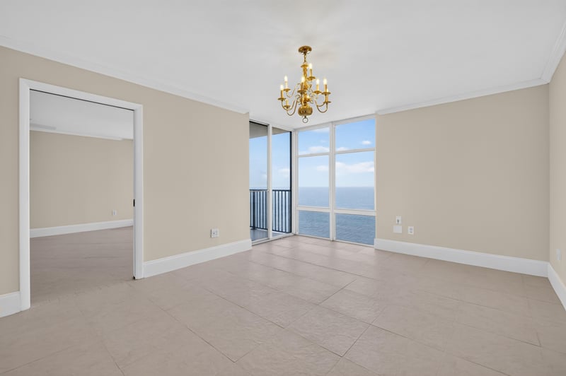 Empty room with chandelier and window views at 1301 1st St S