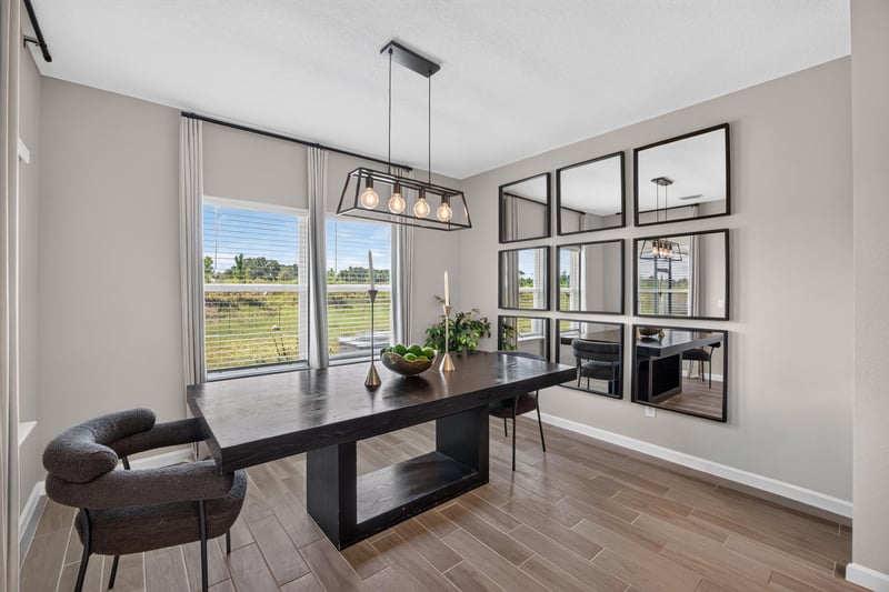 Dining area with long table and pendant lighting at 9942 Lovage Ln, Jacksonville, FL 32219