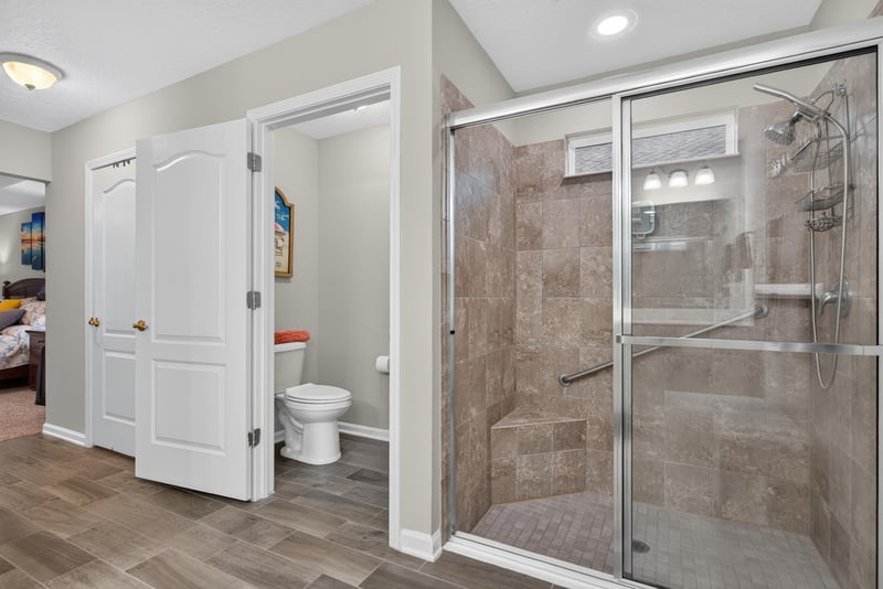 Primary bathroom glass shower and toilet at 4319 Green River Pl, Middleburg, FL 32068