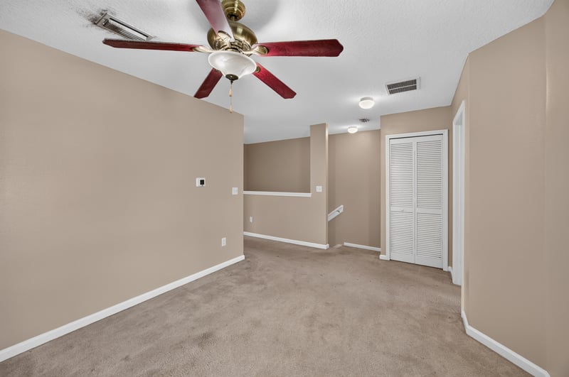 Upstairs hallway with closet doors and ceiling fan at 1572 Biscayne Bay Dr, Jacksonville, FL 32218