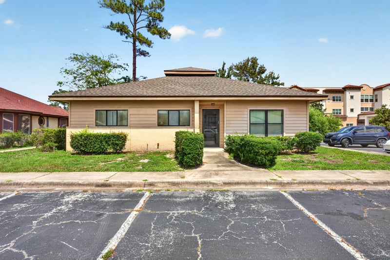 Front exterior with tan brick siding and parking lot at 1543 Kingsley Ave #19, Orange Park, FL 32073