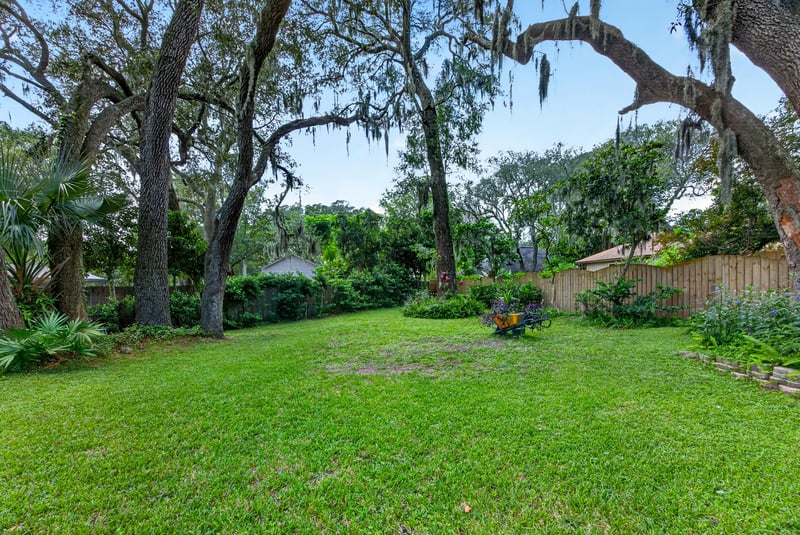 Backyard lawn shaded by mature oaks at 1346 Gately Ct, Jacksonville, FL 32225