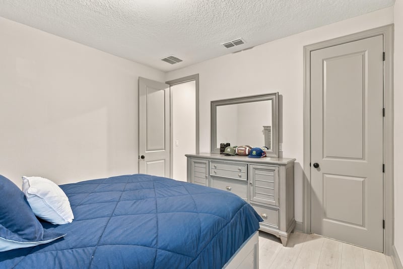Bedroom with navy bedding and window view at 3921 Spyglass Hill Ln
