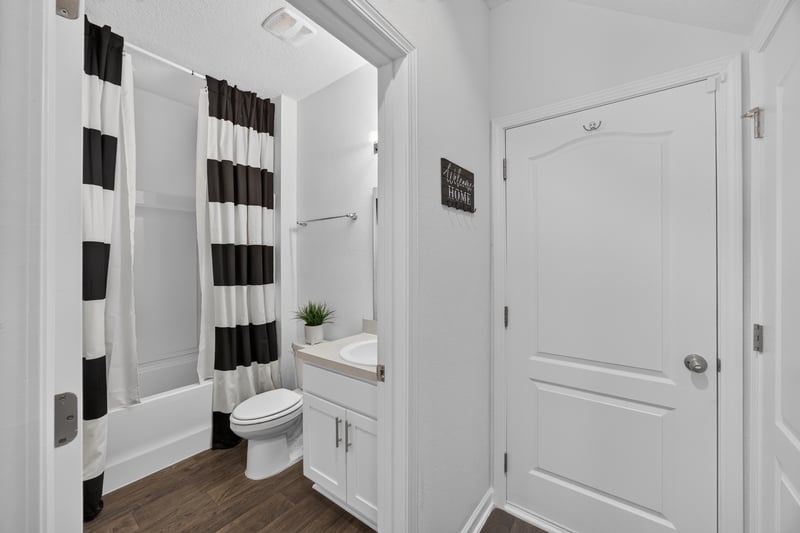 Bathroom with black and white striped shower curtain at 65255 Frst Glen Ln, Yulee, FL 32097