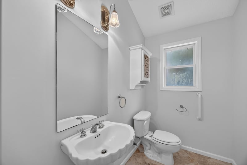 Bathroom with pedestal sink and window at 11675 Magnolia Estates Rd, Jacksonville, FL 32223