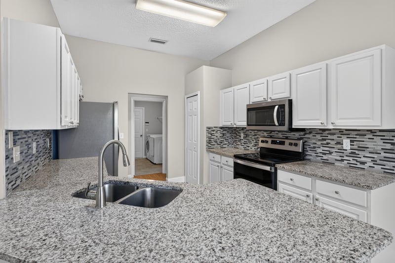 Kitchen with granite island and sink at 12949 Chets Creek Dr S, Jacksonville, FL 32224