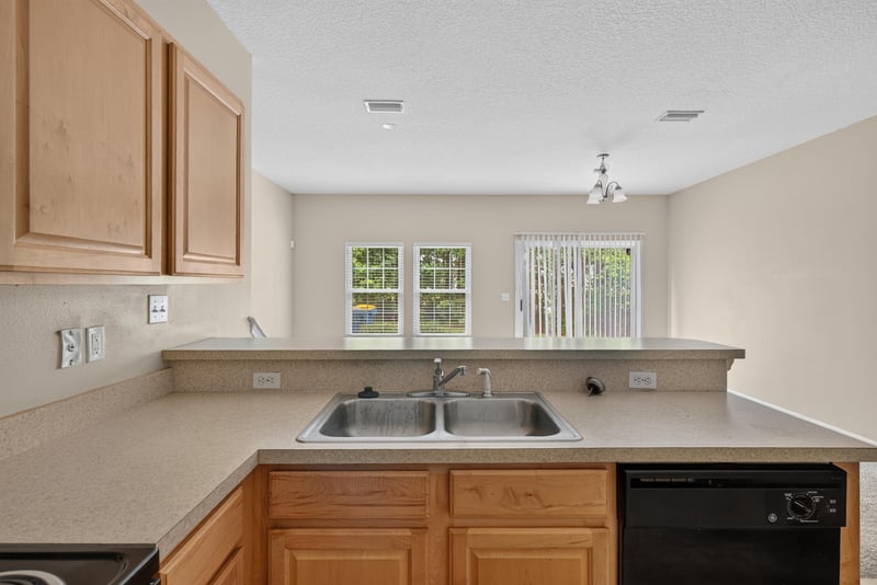 Kitchen sink under window with oak cabinets at 12359 Mangrove Forest Ct, Jacksonville, FL 32218
