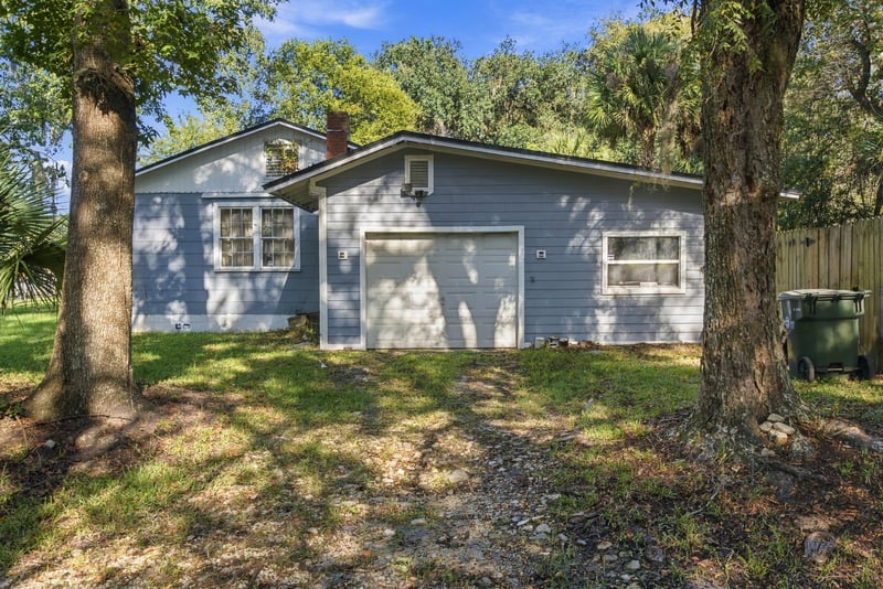 Side exterior view with blue siding and trees at 1807 Idlewild Ave, Green Cove Springs, FL