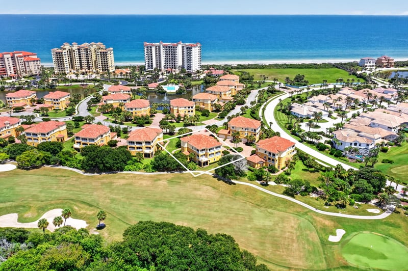 Aerial of golf community rooftops with the ocean beyond in Palm Coast, FL