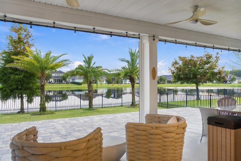 Covered lanai with seating overlooking the pond at 3921 Spyglass Hill Ln