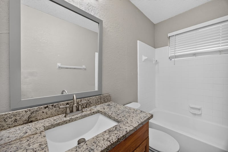Bathroom vanity with granite counter and mirror at 2719 Trollie Ln