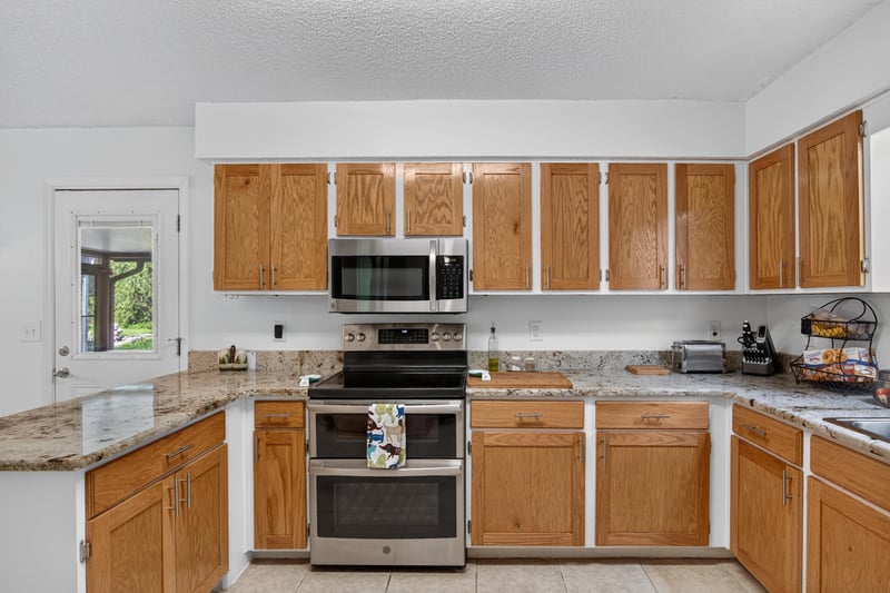 Kitchen with oak cabinets and stainless appliances at 2435 Range Line Rd, Middleburg, FL