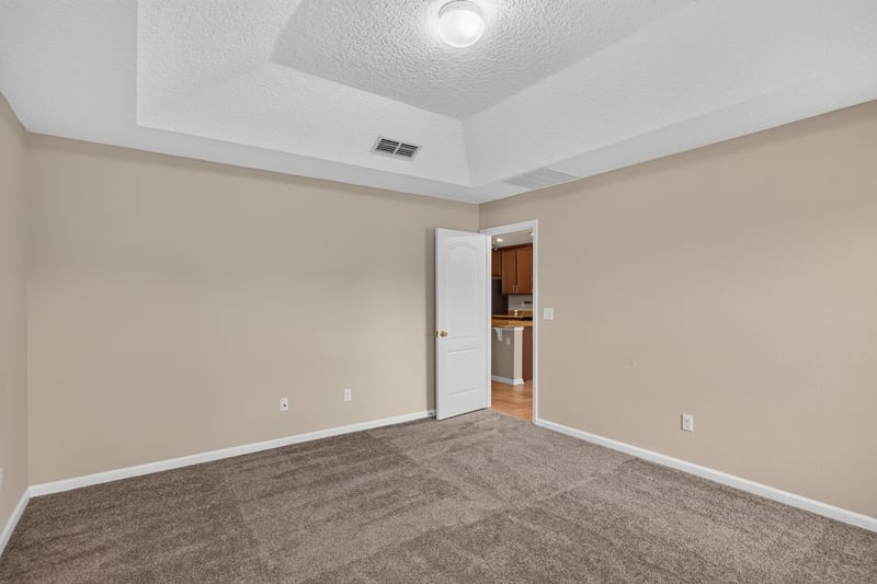 Carpeted bedroom with tray ceiling at 469 Glendale Ln, Orange Park, FL