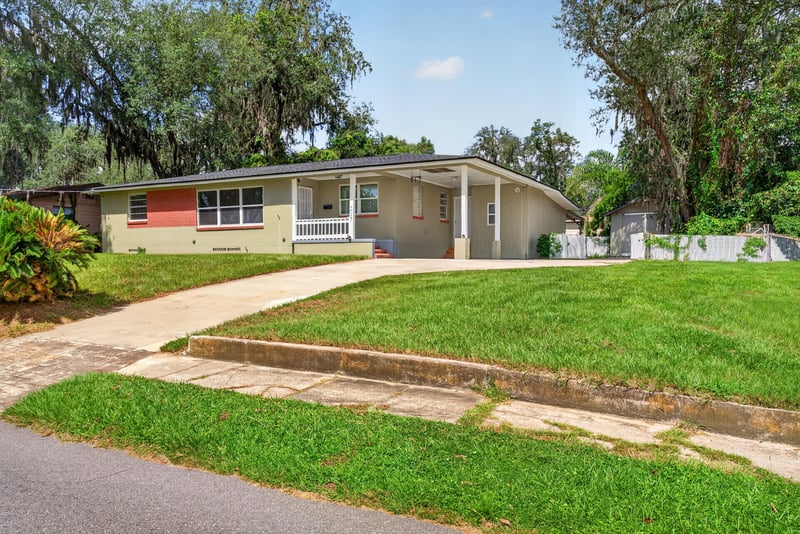 Front exterior with circular driveway and mature oak trees at 217 Baisden Rd, Jacksonville, FL 32218