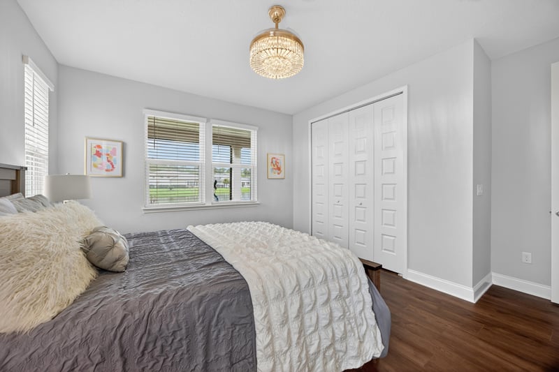 Bedroom with neutral bedding and wood floors at 85491 Fall River Pkwy, Fernandina Beach, FL 32034