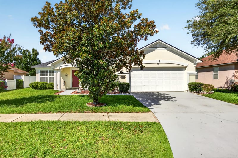 Front exterior with driveway and mature trees at 2282 Justin Lake Dr, Jacksonville, FL
