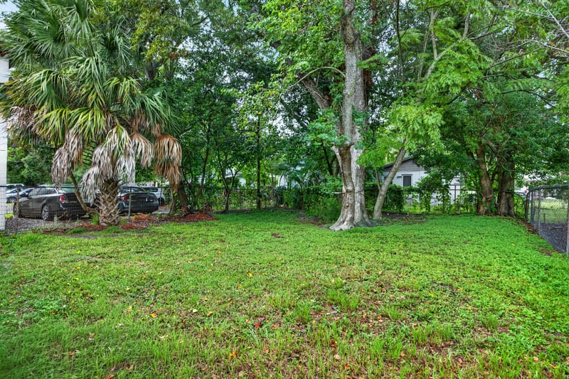 Side yard with grass, trees and fencing at 1473 State St W, Jacksonville, FL 32209