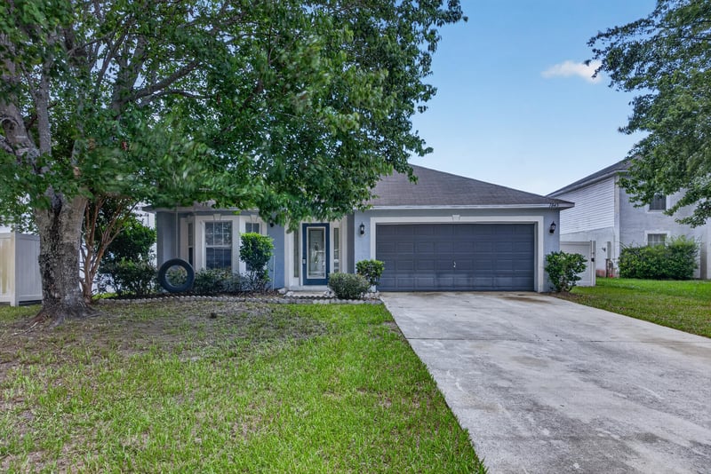 Front exterior with two-car garage and driveway at 1845 Saga Ct, Middleburg, FL