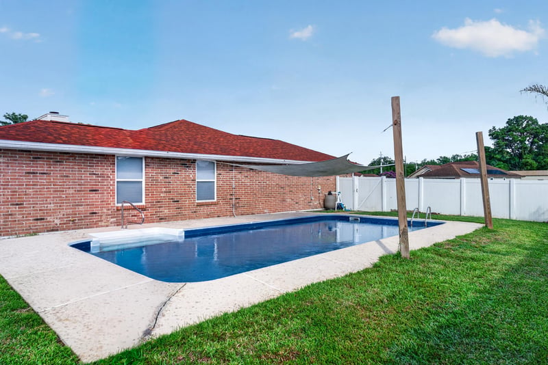 Backyard pool alongside the brick home at 2164 Orangewood St, Middleburg, FL 32068