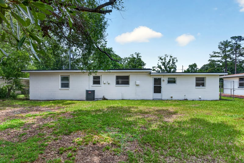 Backyard view with open lawn at 6238 Randia Dr, Jacksonville, FL 32210