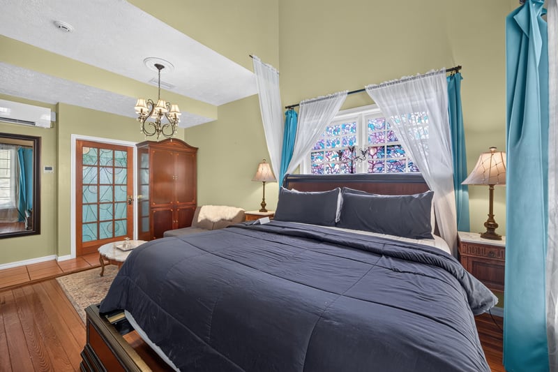 Bedroom with dark bedding and a chandelier at 115 Cordova St, St. Augustine, FL