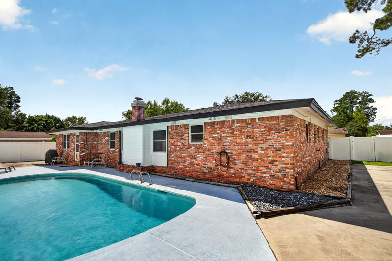 Backyard pool with brick exterior wall at 6059 Karen St, Jacksonville, FL 32244