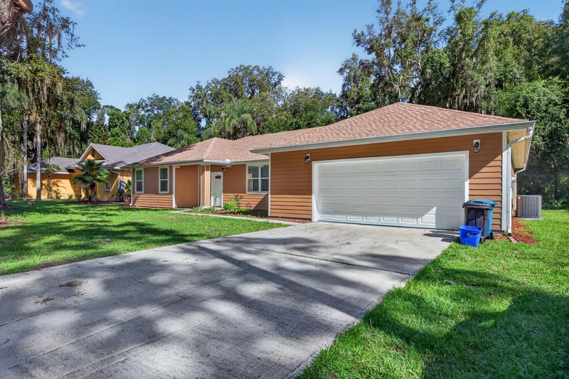 Front exterior with driveway and shaded entry at 1012 Fruit Cove Rd, Jacksonville, FL 32259