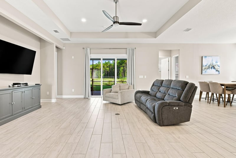 Living room with ceiling fan and sliding glass doors to patio at 27 Holly Rdg Wy, St. Augustine, FL