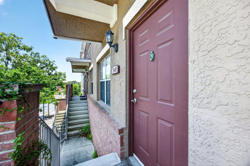 Front entry with maroon door and exterior stairs at 342 E Ashley St, Jacksonville, FL 32202