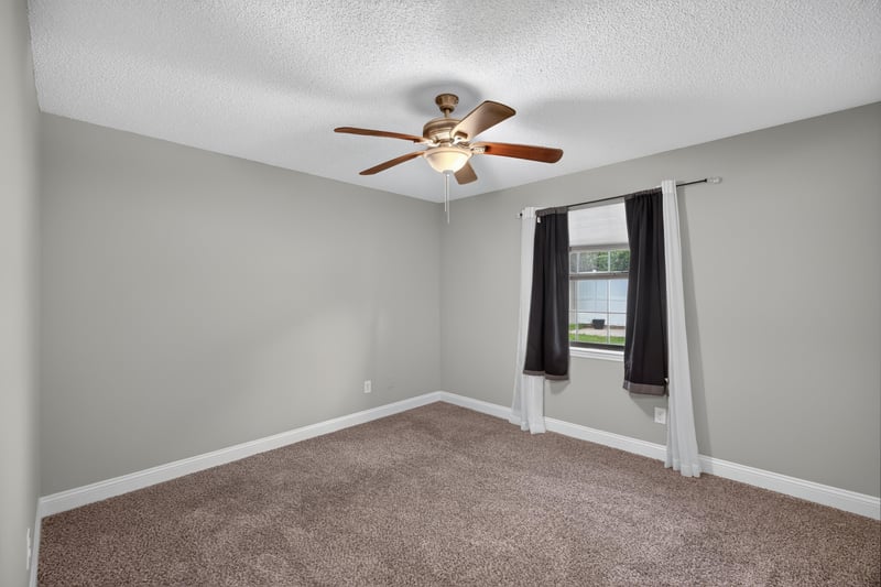 Carpeted bedroom with dark curtain at 12344 Cormorant Ct, Jacksonville, FL