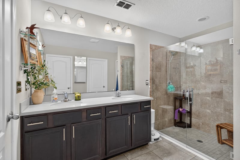 Primary bathroom with dual vanity and dark cabinets at 589 Seville Pkwy, St. Augustine, FL