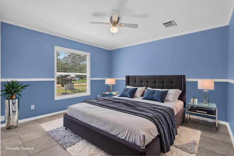Primary bedroom staged with bed and blue walls at 2549 Snapdragon Ave, Middleburg, FL 32068