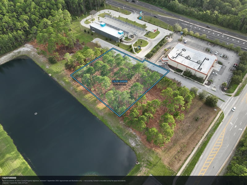 Aerial view of the pond and wooded parcel with parking lot beyond at 4900 US-1, St. Augustine, FL 32086
